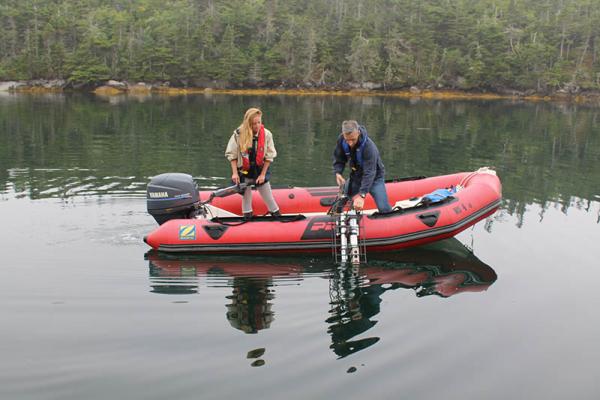People on a boat measuring the water quality of a lake