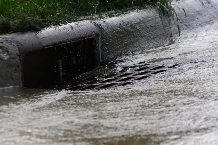 Water running off a road into a storm drain