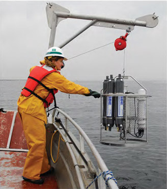 Sea-Bird Scientific SBE 55 ECO Water Sampler on a pulley off the deck of a ship.